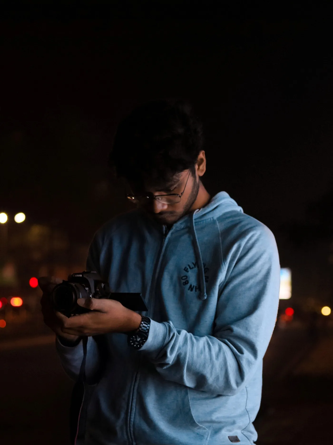 Shubham reviewing a shot on his Canon camera at night
